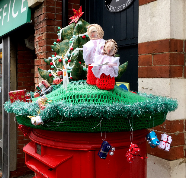 top part of a red postbox, with seasonal decorations